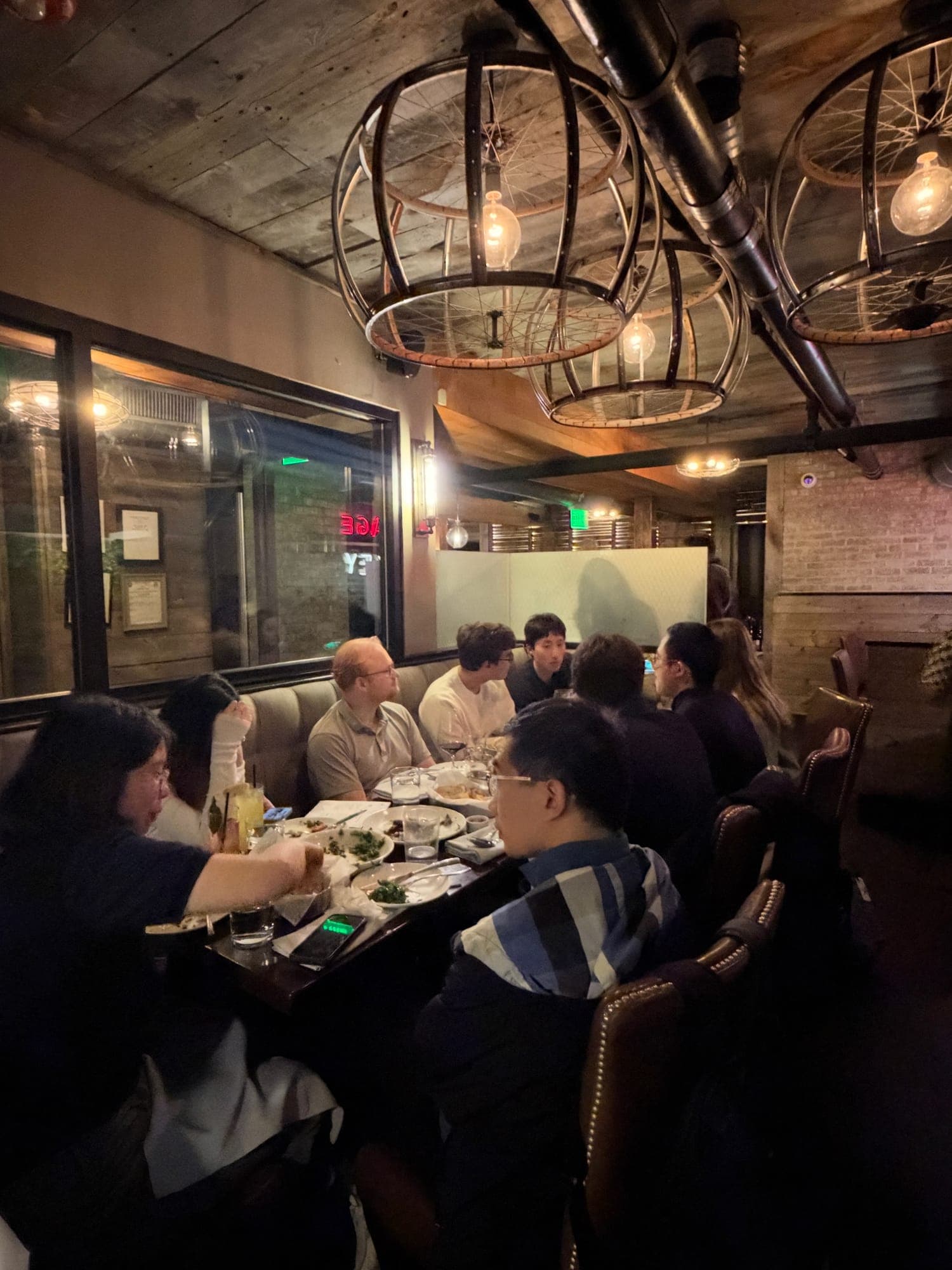 Researchers and the Neurophos team in conversation over dinner at a Research Corner event